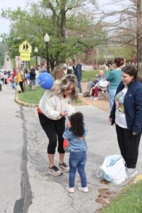 Woman handing out balloon to child