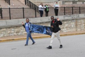 Users walking with banner in parade